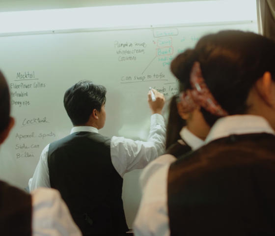 Hospitality students plan for service on a whiteboard.